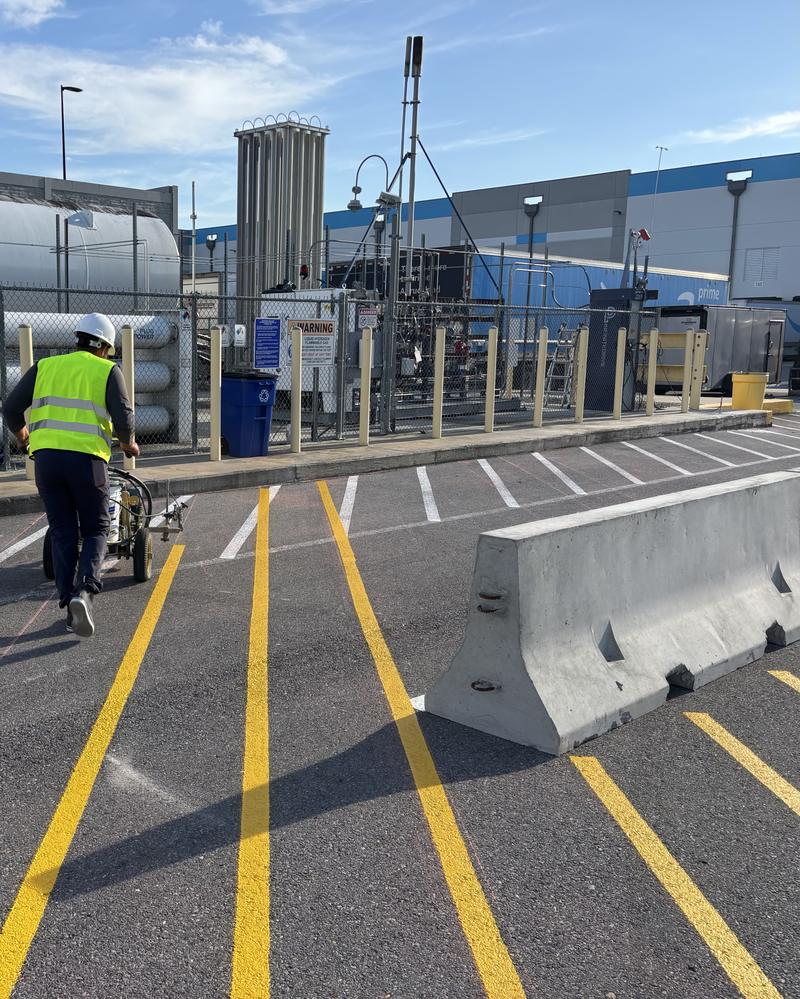 Fresh yellow lines beside a concrete barrier at a distribution center in Carencro, LA