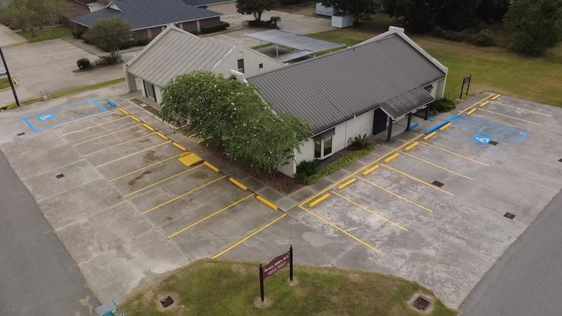 Aerial view of a medical office in Eunice, LA with fresh yellow stall lines, yellow wheel stops and blue accessible spaces
